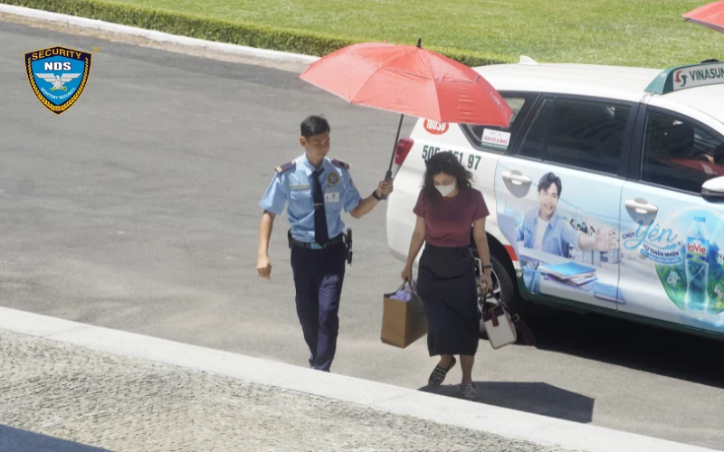 Nhân viên Ngày và Đêm che ô và hướng dẫn khách xuống xe