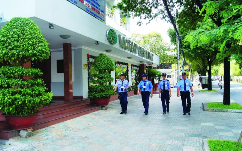 Bốn nhân viên bảo vệ tuần tra trên vỉa hè trước nhà hàng Victory