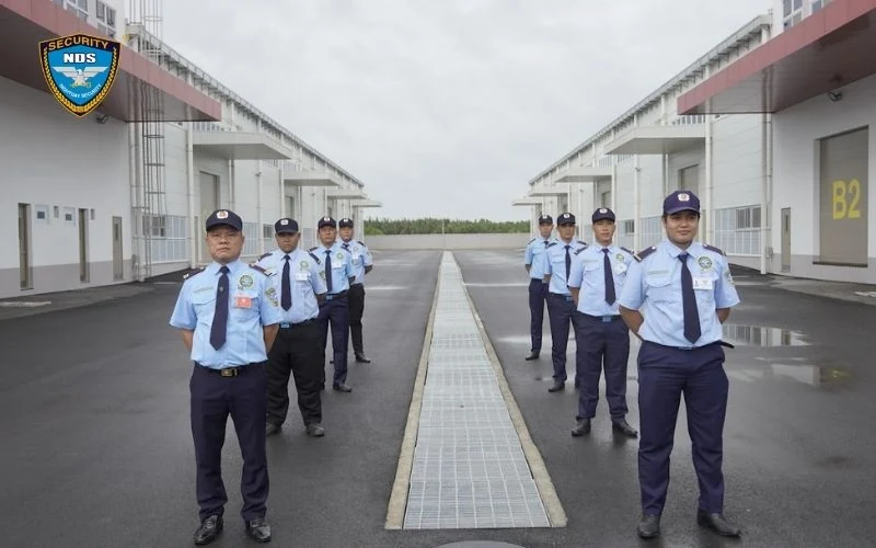 Dịch vụ bảo vệ khu công nghiệp 25 Đội bảo vệ di chuyển trên lối đi giữa hai dãy nhà xưởng