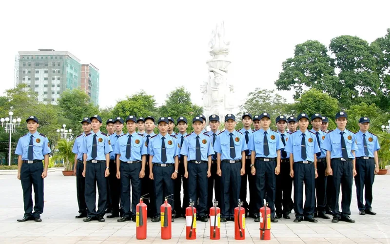 Đội bảo vệ xếp hàng sau dãy bình chữa cháy trong buổi huấn luyện phòng cháy chữa cháy