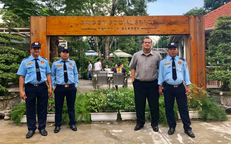 Top 12 công ty bảo vệ TPHCM uy tín, chuyên nghiệp 19 Nhân viên Long Hải Securitas đứng cùng khách tại cổng trường