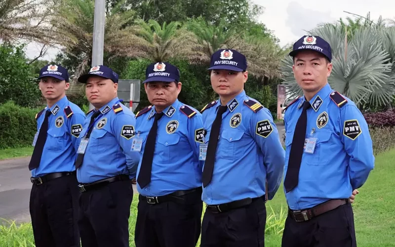 Top 12 công ty bảo vệ TPHCM uy tín, chuyên nghiệp 24 Nhân viên Thanh Bình Phú Mỹ mặc đồng phục xanh đứng cạnh cây xanh